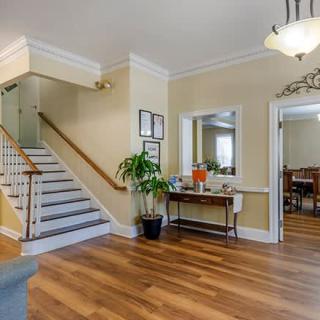 A welcoming foyer with a staircase, hardwood flooring, and elegant decor.