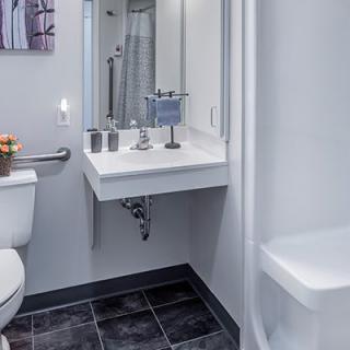 A modern and clean bathroom featuring a sink with a mirror and toilet.