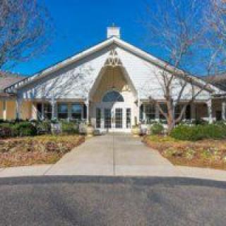 A symmetrical building with a prominent entrance and surrounding trees.