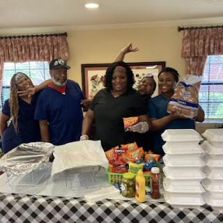 A joyful gathering of team members celebrating with a delicious spread of food.