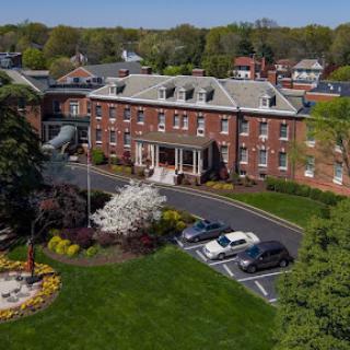 Aerial view of a brick building with landscaped gardens and parking.