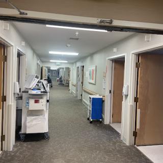 A view of a hospital hallway featuring medical equipment and closed doors.