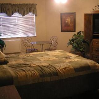 A cozy bedroom with a large bed, wooden furniture, and tasteful decorations.
