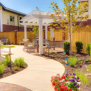 A beautifully landscaped garden with a winding path and pergola.