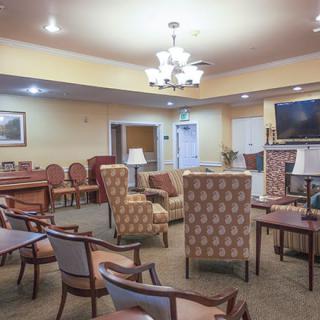 A cozy lounge with patterned chairs and tables, featuring warm lighting.