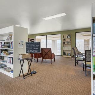 A cozy library interior with bookshelves and seating areas for reading.