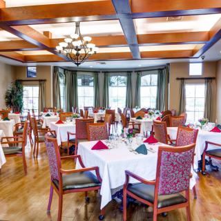 A bright and elegantly decorated restaurant dining room with neatly arranged tables and chairs.