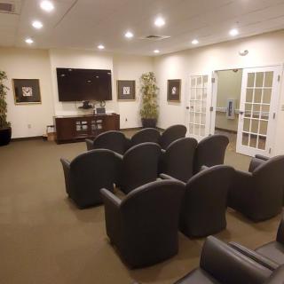 A modern waiting room with comfortable seating and a television.