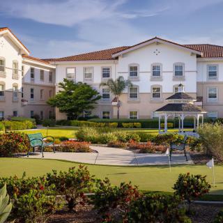 A residential building with well-maintained gardens and outdoor pathways.