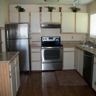 Modern kitchen with stainless steel appliances and wooden cabinets.