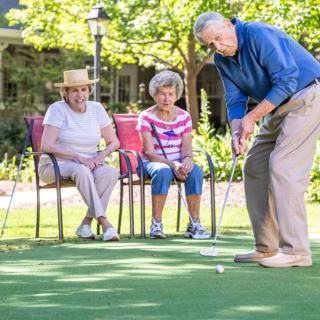 A group of seniors enjoying a game of golf outdoors.
