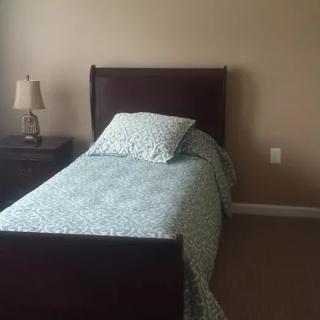 A minimalist bedroom with a single bed and nightstand.