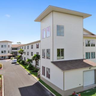 A modern residential building showcasing contemporary architecture in a sunny urban environment.