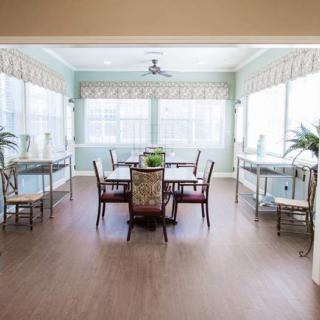 A bright dining room with large windows, natural light, and elegant furniture.