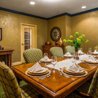 An elegant dining room with a beautifully set table, ready for a formal dinner.