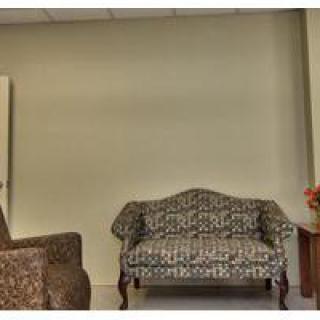 A cozy seating area with a patterned sofa, armchair, and small side table.