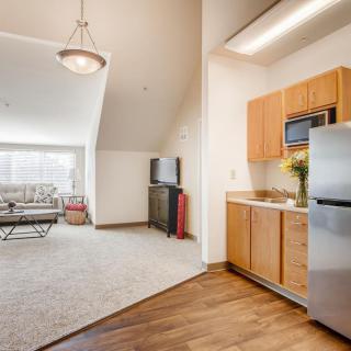 A modern apartment with an open floor plan featuring a kitchen and a cozy living room area.