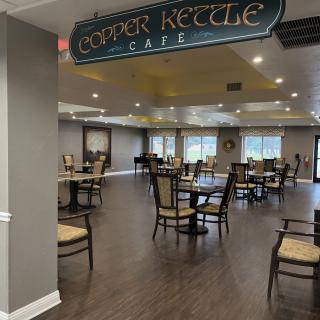 The Copper Kettle Cafe features an inviting seating area with wooden flooring and ample natural light.