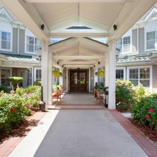A well-maintained building entrance with a covered walkway and vibrant landscaping.