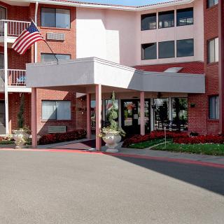 The image shows the entrance of a residential building with an American flag displayed above.