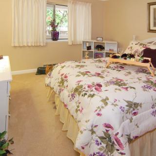 A cozy bedroom with floral bedding and warm decor.