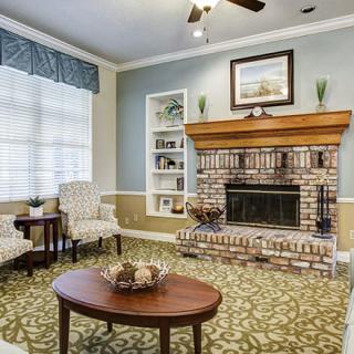 A cozy living room with a brick fireplace and elegant furnishings.