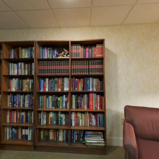 A cozy reading room with a well-stocked bookshelf filled with various books.