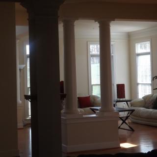 A cozy living room with elegant columns and ample natural light.