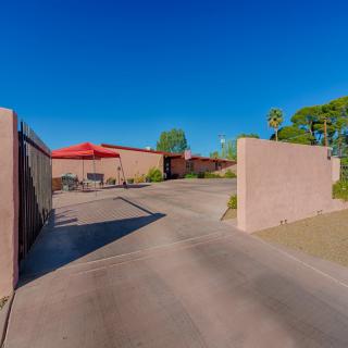 Modern house with a driveway in a desert setting under a clear blue sky.