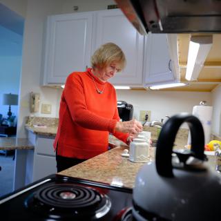 A woman preparing food in a kitchen setting.