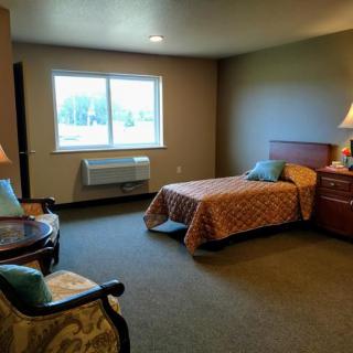 A cozy bedroom with a single bed, window, and furniture.