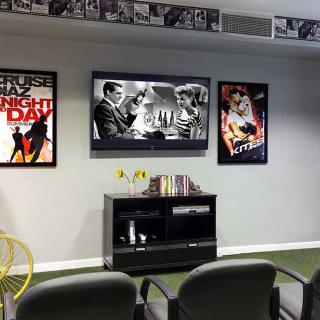 A cozy home theater setup featuring classic movie posters and a wall-mounted television.