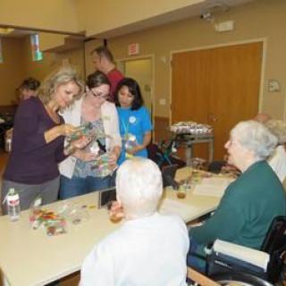 Volunteers engage with seniors during an activity session at a nursing home.