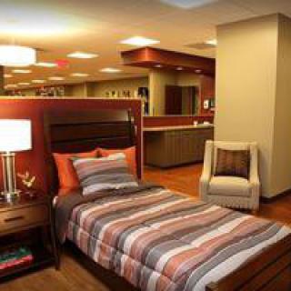 A modern bedroom with striped bedding and ambient lighting.