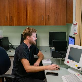A man working at a computer in an office setting.