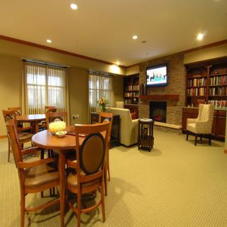 A cozy living room with a seating area, bookshelves, and a fireplace.