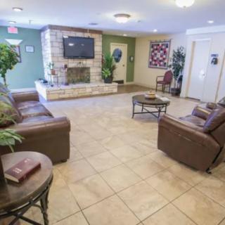 A spacious lobby with comfortable seating, a fireplace, and a television.