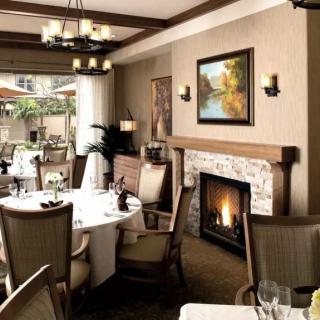 A cozy restaurant dining room featuring a fireplace and elegant table settings.