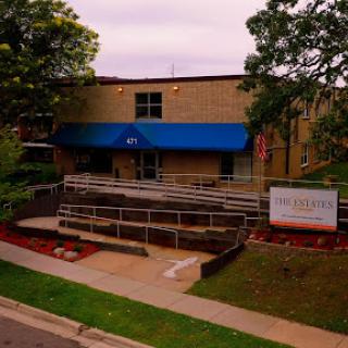 A modern building featuring a blue awning and accessible entrance.