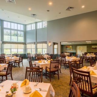 A spacious and well-lit dining area with neatly arranged tables and chairs.