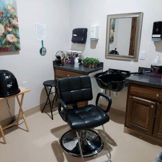 A cozy hair salon setup featuring a barber chair, mirror, and styling tools.