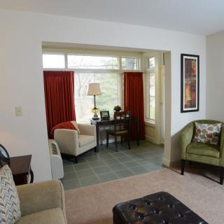 A cozy living room with comfortable armchairs and a view through large windows.
