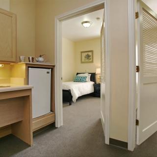 A cozy hotel room featuring a comfortable bed and a small desk area.