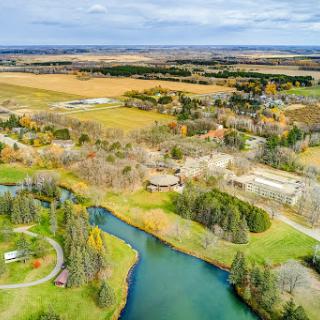 A serene aerial view of a lush rural landscape featuring a winding river and sprawling fields.
