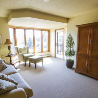 A cozy living room with large windows and comfortable seating.