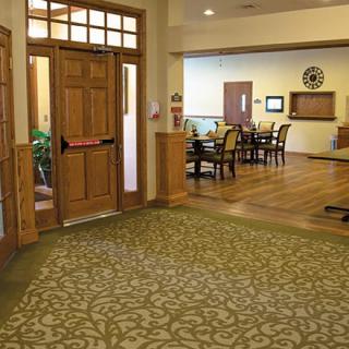 A cozy lobby area featuring wooden doors, comfortable seating, and a patterned carpet.