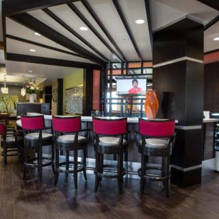 A modern bar interior with red and black seating.