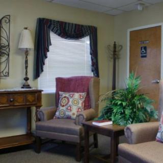Cozy waiting room with armchairs, a lamp, and decorative elements.