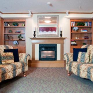 A cozy living room with a fireplace flanked by shelves and armchairs.