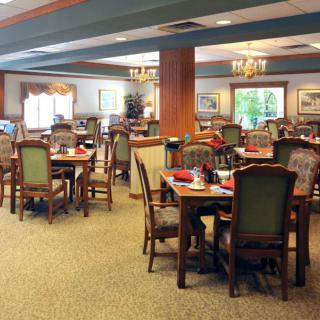 A spacious and elegantly decorated dining room with multiple tables and chairs arranged neatly.